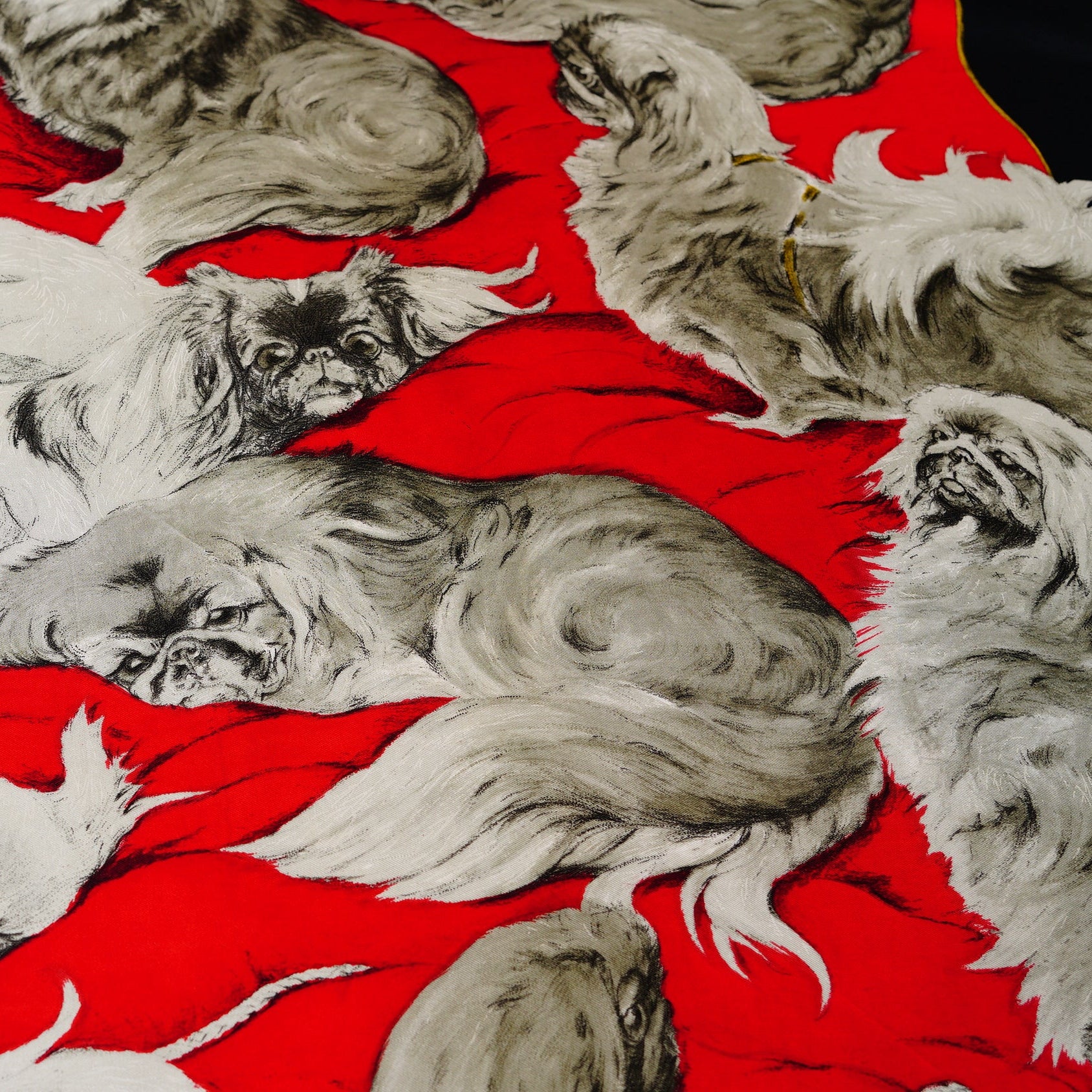 Illustration d'un chien Pékinois assis, pièce de collection Hermès rare en soie rouge et noire.