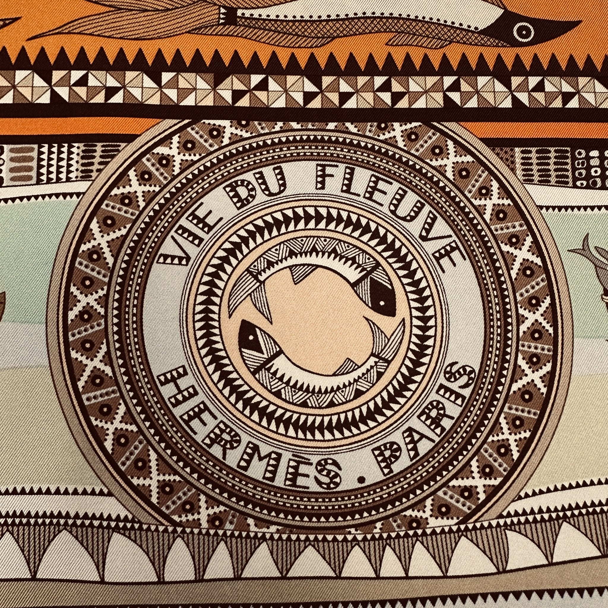 médaillon central avec le nom du foulard foulard la vie du fleuve orange et signature hermes paris