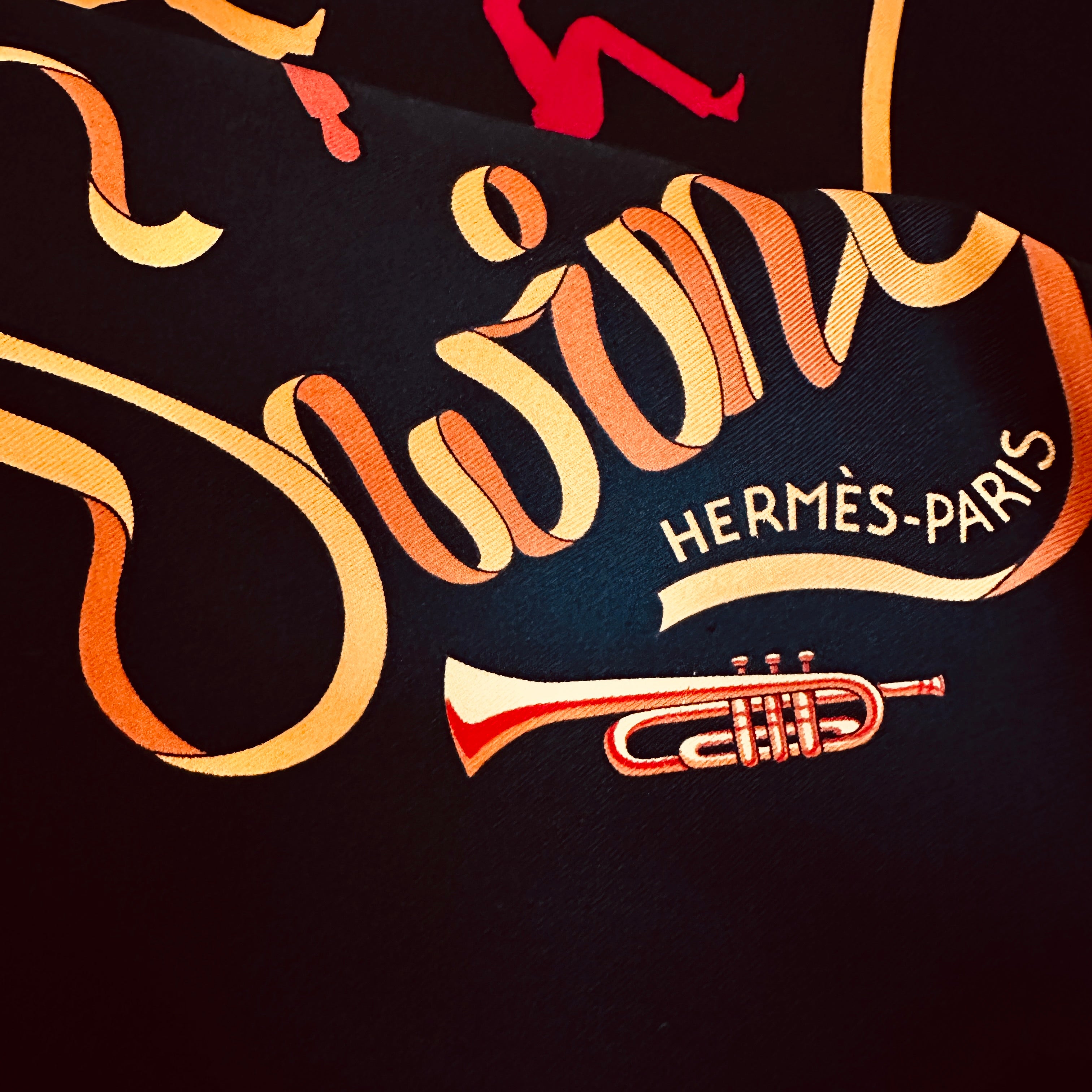 Coin du foulard avec inscription "Swing", trompette et signature "Hermès-Paris"