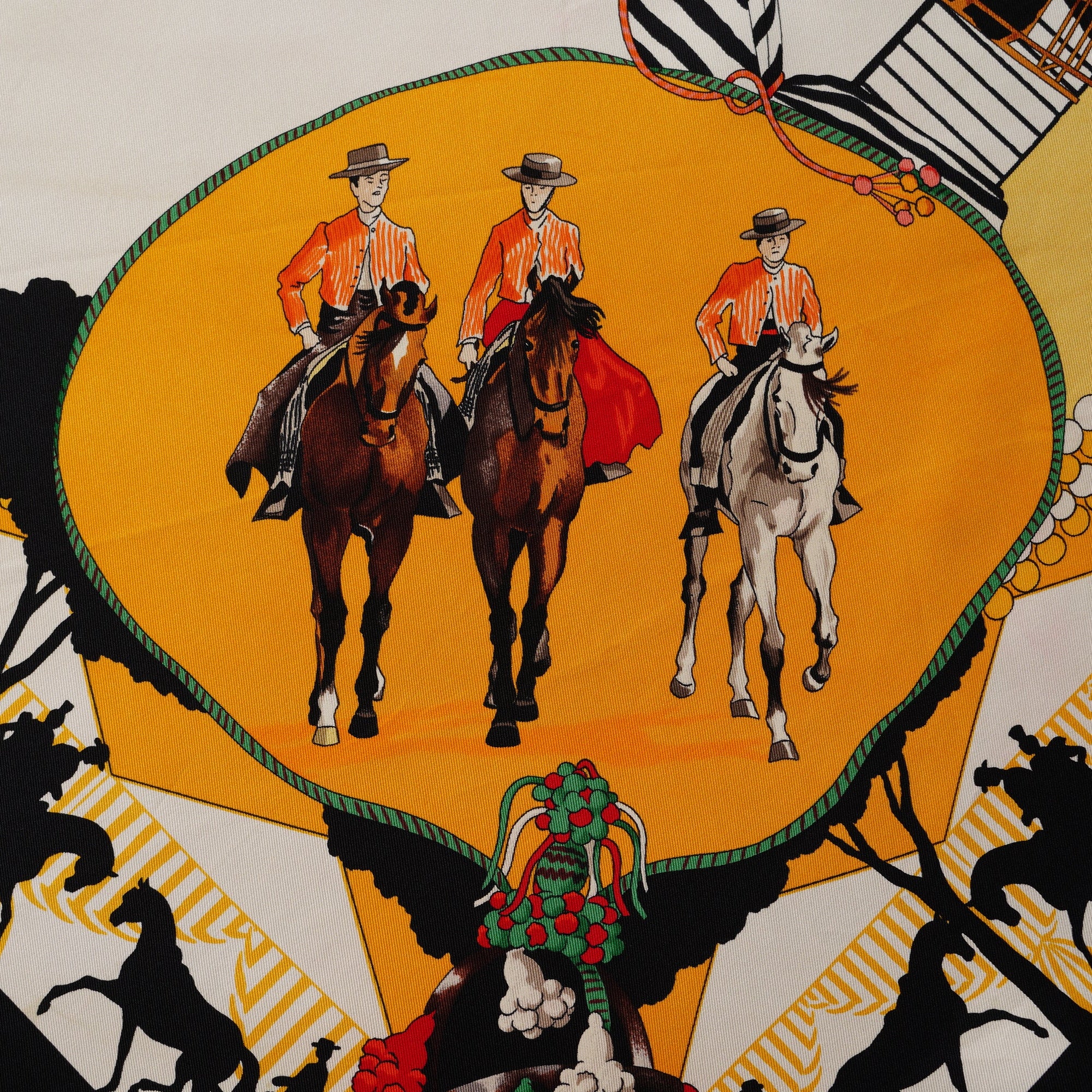 Gros plan sur un médaillon illustrant trois cavaliers andalous sur fond jaune ensoleillé.