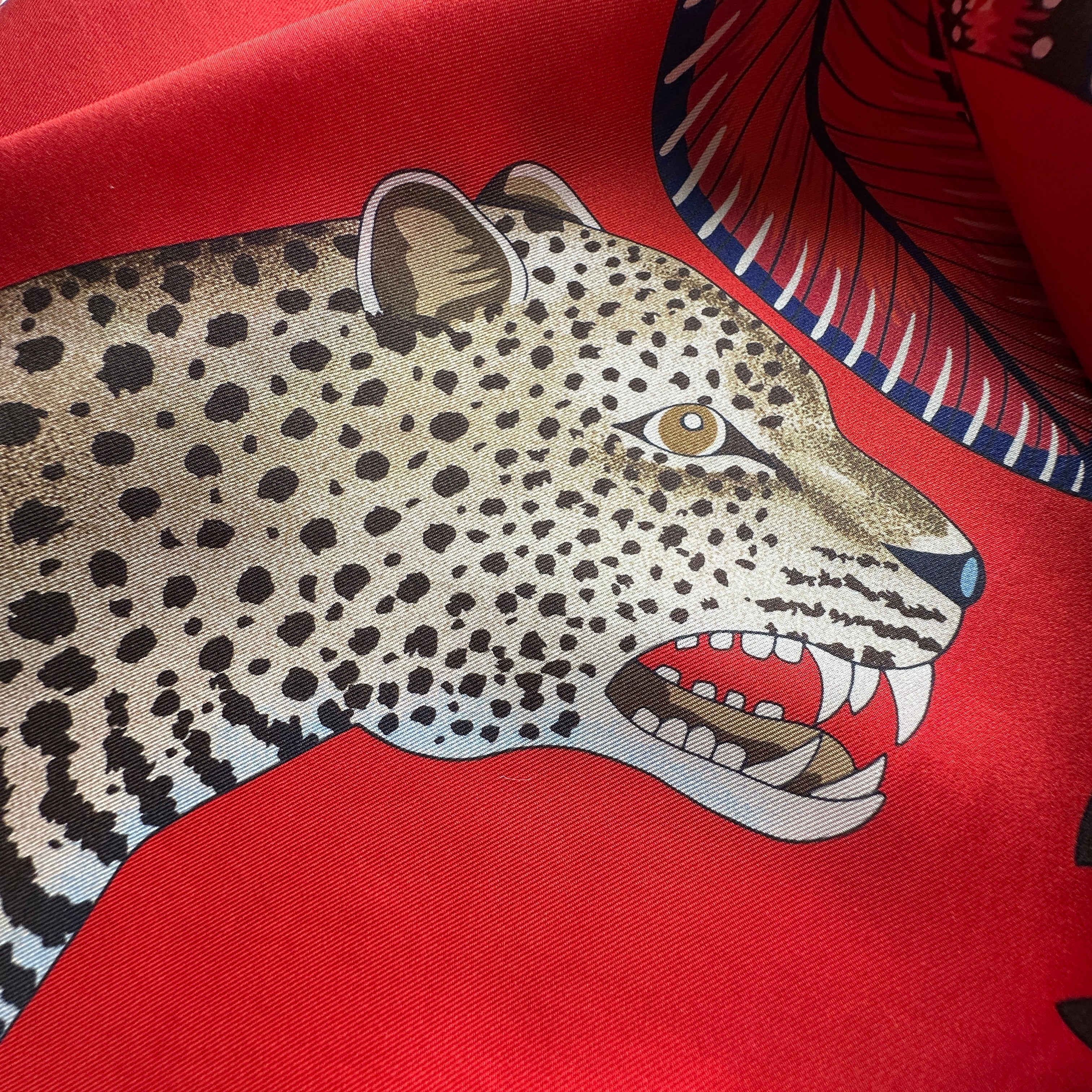 Gros plan de la tête de léopard et du motif africain, châle Hermès 140 cm